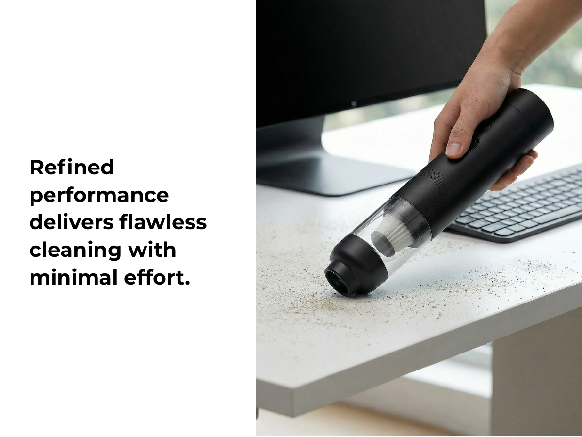 Hand using a handheld vacuum cleaner on a desk with text about refined performance.